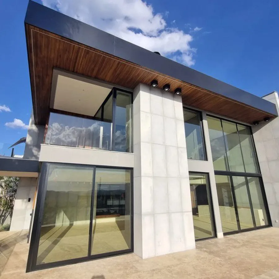 Casa moderna con grandes ventanales de vidrio con lámina semitransparente